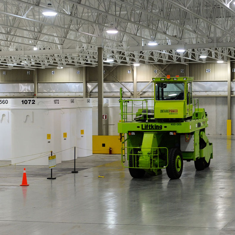 A photograph of a large fork lift vehicle inside an OPG waste storage facility that is used to lift the storage containers.