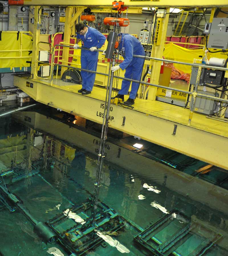 A photograph of two fuel handlers working above the Secondary Fuel Bay.